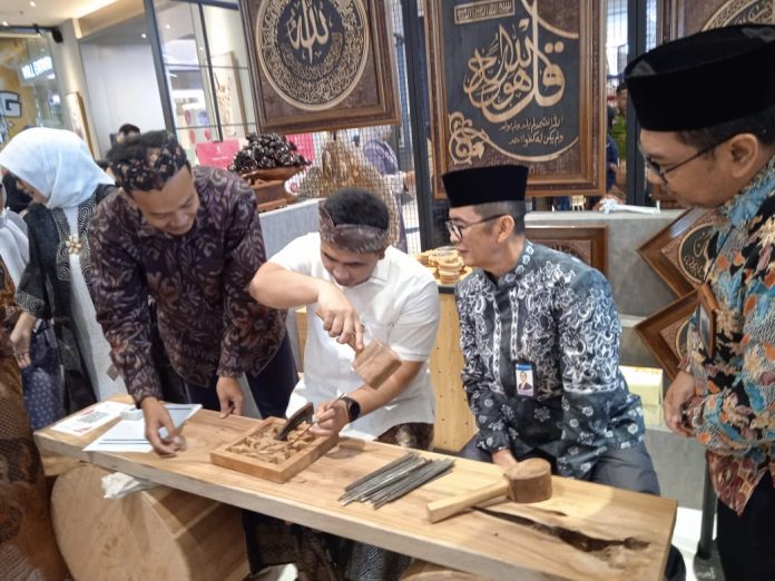 Wakil Gubernur Jawa Tengah Taj Yasin (tengah kiri) bersama Kepala KPw BI Jateng Rahmat Dwisaputra (tengah kanan) belajar mengukir kaligrafi di salah satu stand pameran FAJAR 2025 di Queen City Mall Semarang pada Kamis (14/8).