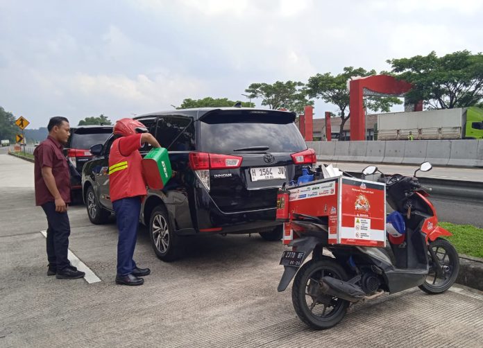 Petugas motoris melayani konsumen yang kehabisan bahan bakar di dekat rest area KM 456 A ruas tol Semarang–Solo pada Kamis (12/3).