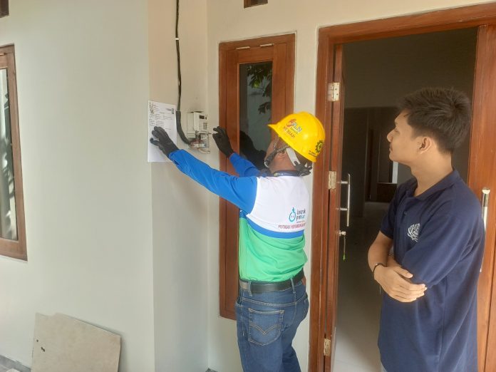 Petugas melakukan proses penambahan daya di rumah Alfonso, warga Banyumanik