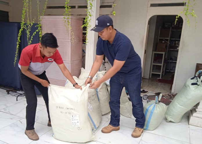 Direktur PT Moko Garment Indonesia, Ryan Muhammad, tengah menyiapkan produk kiriman bersama petugas JNE.