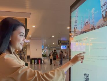 Suasana penumpang menggunakan layar interaktif Digital Wayfinding di Bandara Internasional Jenderal Ahmad Yani Semarang.